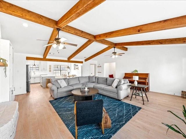 living room with ceiling fan, vaulted ceiling with beams, and light hardwood / wood-style floors