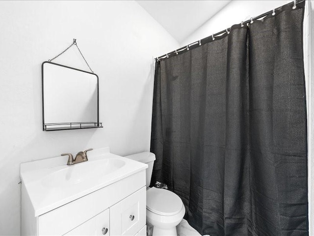 bathroom featuring vanity, vaulted ceiling, and toilet