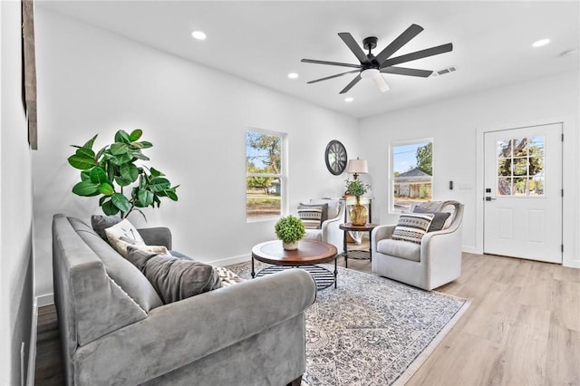 living room with light wood-type flooring and ceiling fan