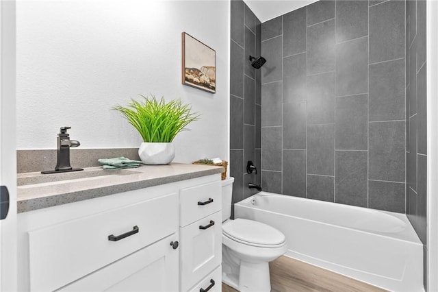 full bathroom featuring vanity, hardwood / wood-style flooring, toilet, and tiled shower / bath