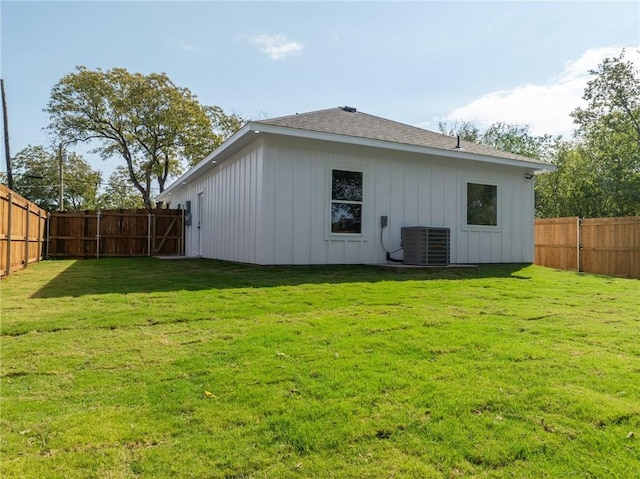 back of house with a yard and central AC