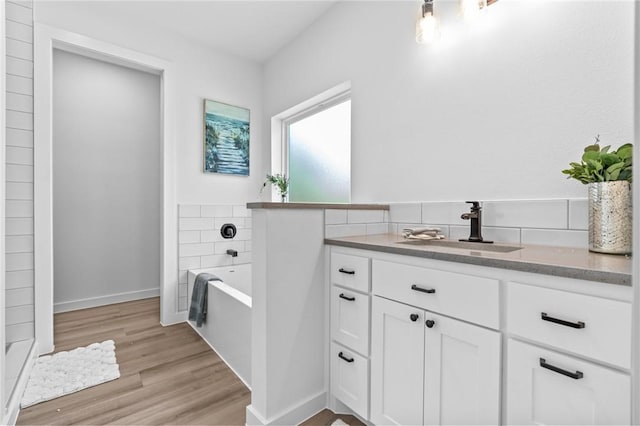 bathroom with hardwood / wood-style floors, vanity, and a bath