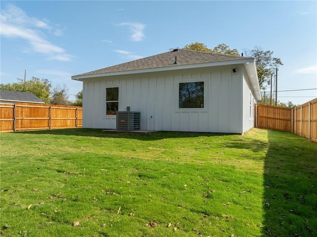 rear view of house featuring a lawn and central AC