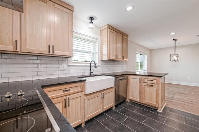 kitchen featuring light brown cabinets, sink, stainless steel dishwasher, decorative light fixtures, and kitchen peninsula