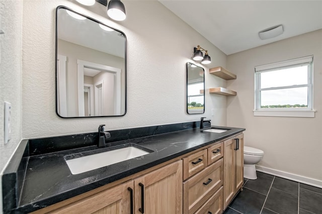 bathroom with tile patterned flooring, vanity, and toilet