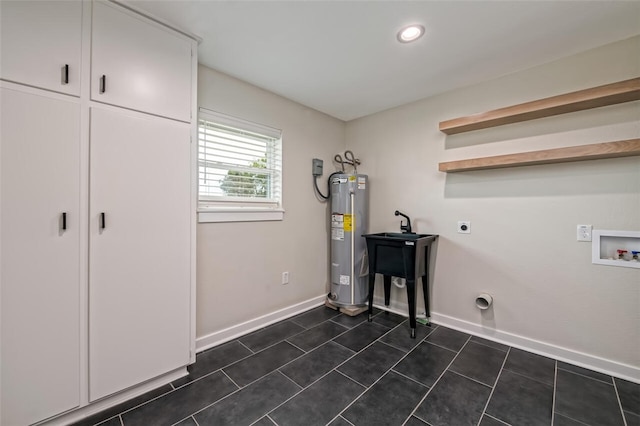 washroom featuring cabinets, washer hookup, electric dryer hookup, water heater, and dark tile patterned flooring