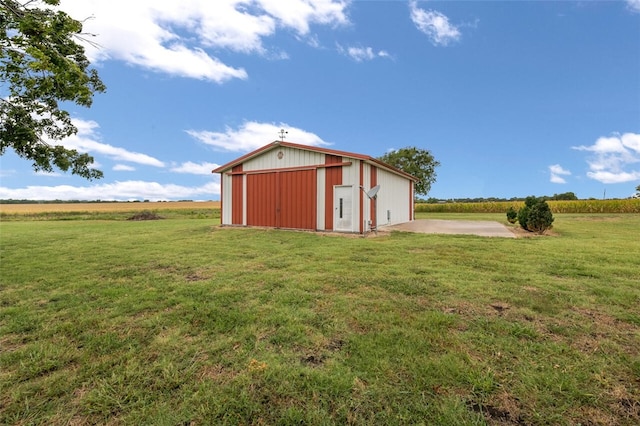 view of outdoor structure with a lawn and a rural view