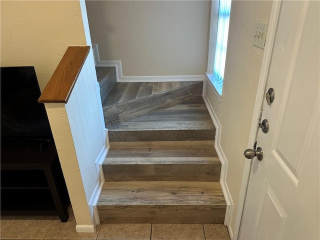 stairway featuring tile patterned flooring