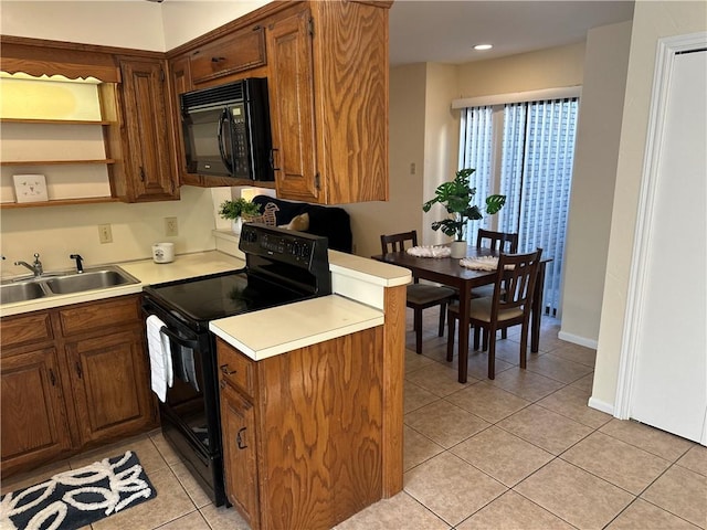 kitchen with sink, light tile patterned floors, and black appliances