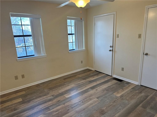 interior space with ceiling fan, a healthy amount of sunlight, and dark hardwood / wood-style floors