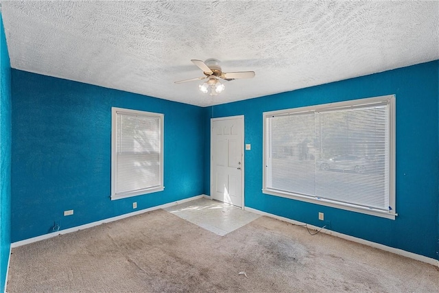 carpeted empty room featuring a textured ceiling and ceiling fan