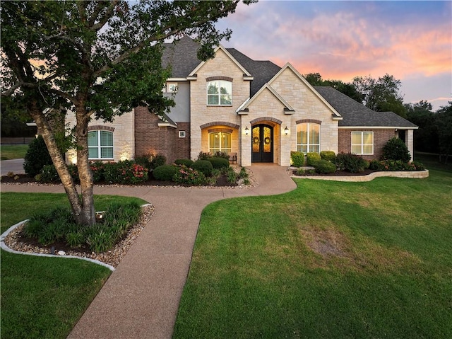 french country style house with a lawn and french doors