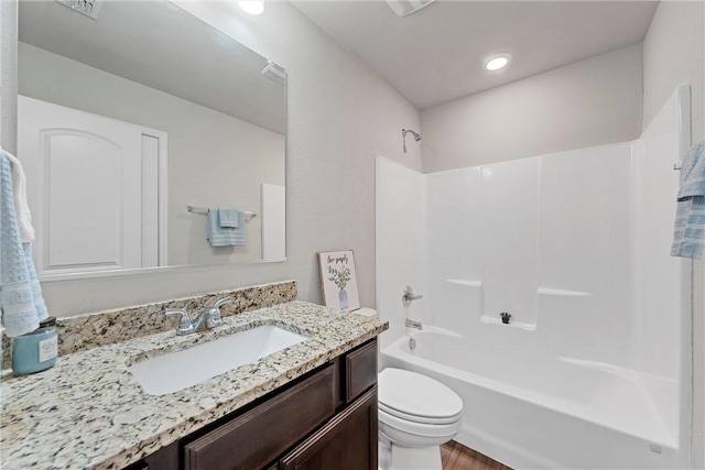 full bathroom featuring shower / bathing tub combination, vanity, hardwood / wood-style flooring, and toilet