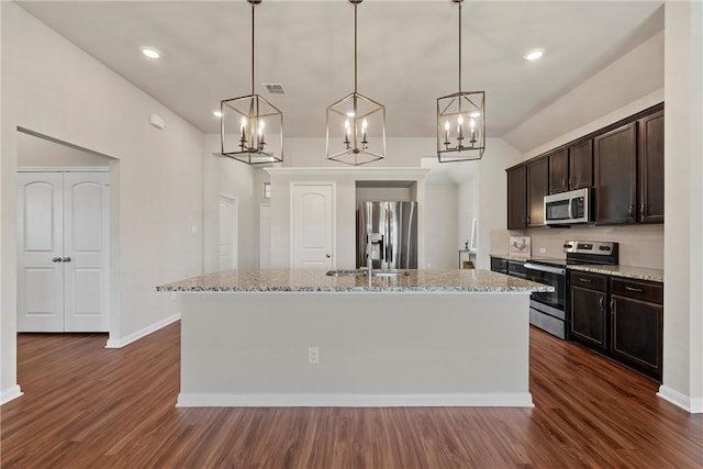 kitchen featuring decorative light fixtures, dark hardwood / wood-style flooring, stainless steel appliances, and a center island with sink