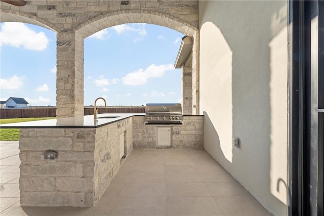 view of patio / terrace with area for grilling, a grill, and sink