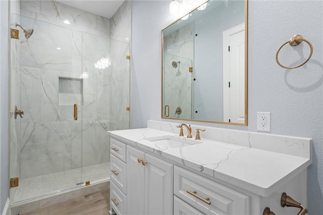 bathroom featuring hardwood / wood-style flooring, vanity, and walk in shower