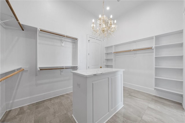 walk in closet with a chandelier and high vaulted ceiling