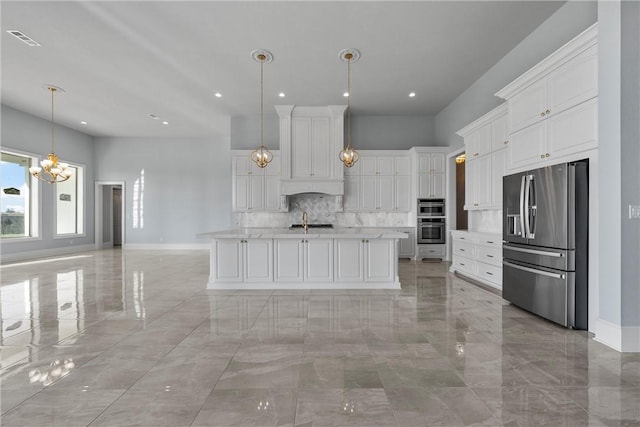 kitchen featuring stainless steel appliances, sink, a center island with sink, white cabinets, and hanging light fixtures