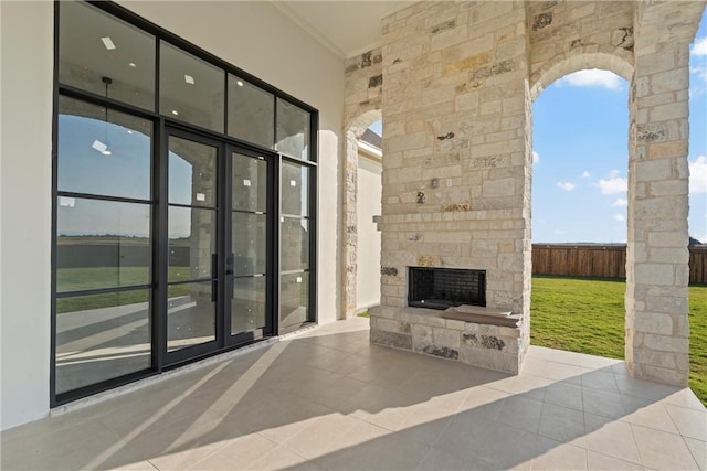 view of patio with french doors and an outdoor stone fireplace