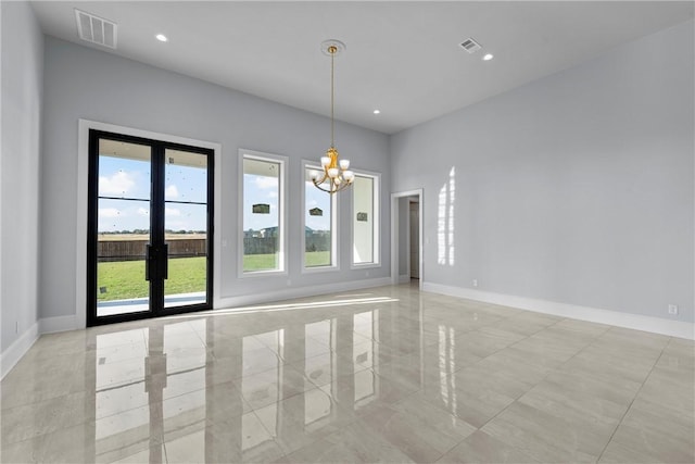 unfurnished room with french doors and a notable chandelier