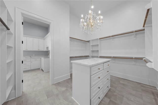 spacious closet featuring a notable chandelier and high vaulted ceiling