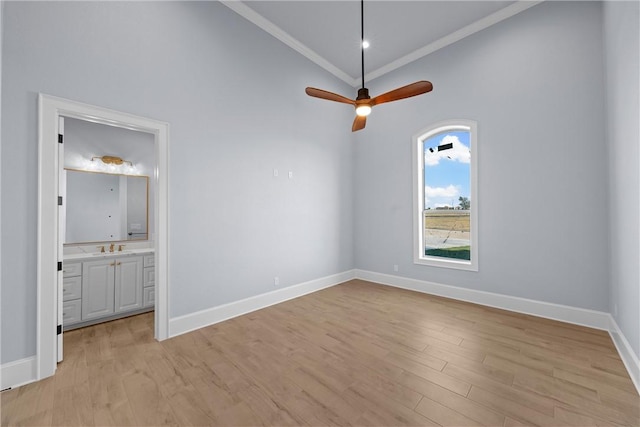 spare room with ceiling fan, light wood-type flooring, ornamental molding, and vaulted ceiling