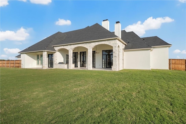 back of house featuring a patio and a lawn