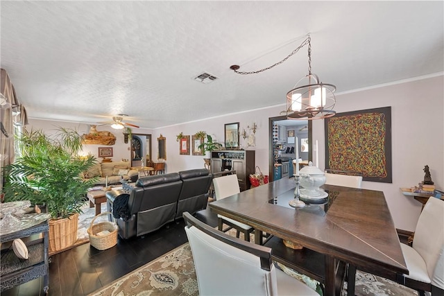 dining area featuring ceiling fan, crown molding, a textured ceiling, and hardwood / wood-style flooring