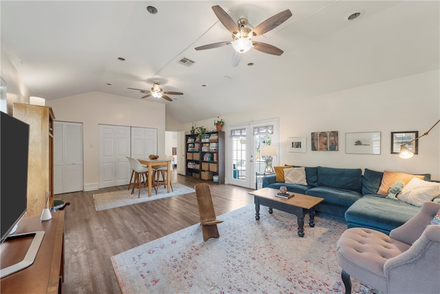 living room with vaulted ceiling, french doors, wood finished floors, and visible vents