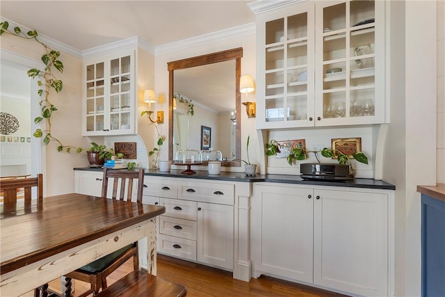 bar with wood finished floors and crown molding