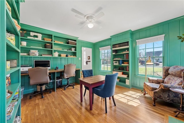 home office with light wood-type flooring and a ceiling fan