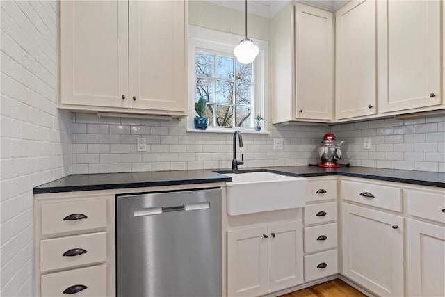 kitchen with dark countertops, a sink, backsplash, and stainless steel dishwasher