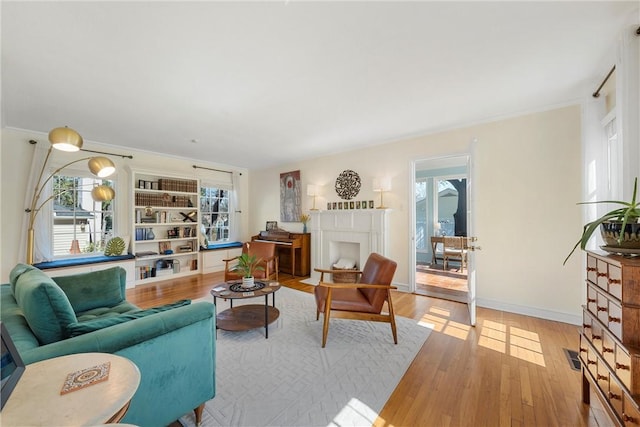 living room with a fireplace with flush hearth, wood finished floors, and baseboards