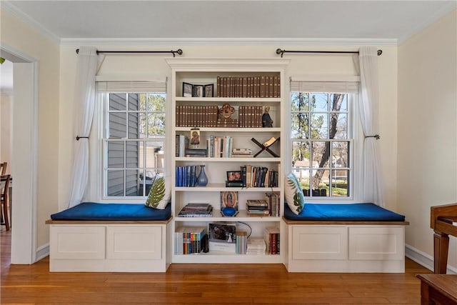 interior space with crown molding, baseboards, and wood finished floors