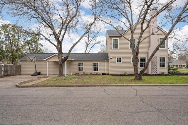 view of front of home with a front yard and fence