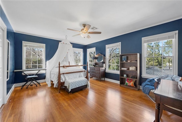 bedroom featuring visible vents, multiple windows, and hardwood / wood-style flooring