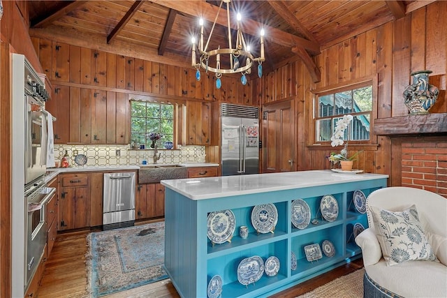 kitchen with plenty of natural light, light hardwood / wood-style flooring, wood ceiling, and appliances with stainless steel finishes