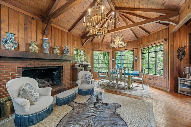 interior space featuring a fireplace, lofted ceiling with beams, light hardwood / wood-style flooring, and wooden ceiling