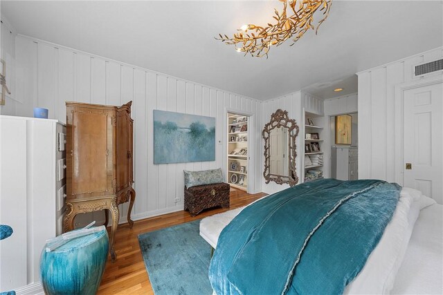 bedroom with wood-type flooring and a notable chandelier