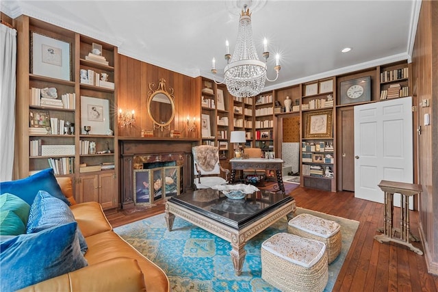 living room featuring a chandelier, dark hardwood / wood-style flooring, ornamental molding, and a premium fireplace