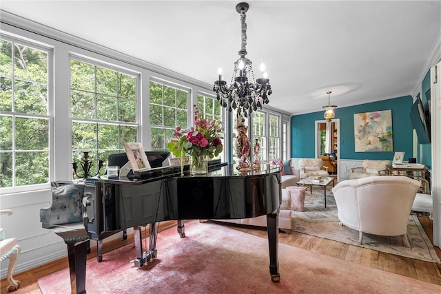 misc room featuring a chandelier, hardwood / wood-style flooring, and crown molding