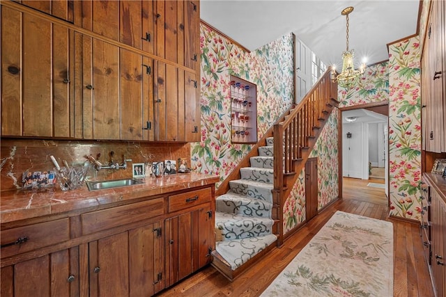 kitchen featuring hardwood / wood-style flooring, decorative light fixtures, decorative backsplash, and a notable chandelier