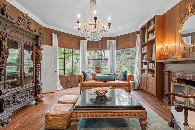 sitting room featuring wood walls, crown molding, and light hardwood / wood-style floors