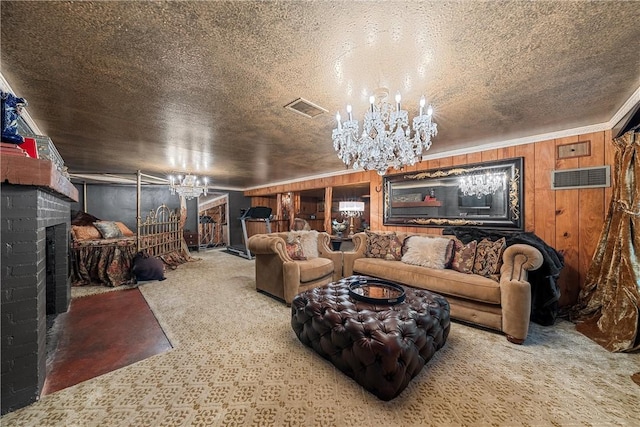 carpeted living room featuring an inviting chandelier, wooden walls, a brick fireplace, ornamental molding, and a textured ceiling