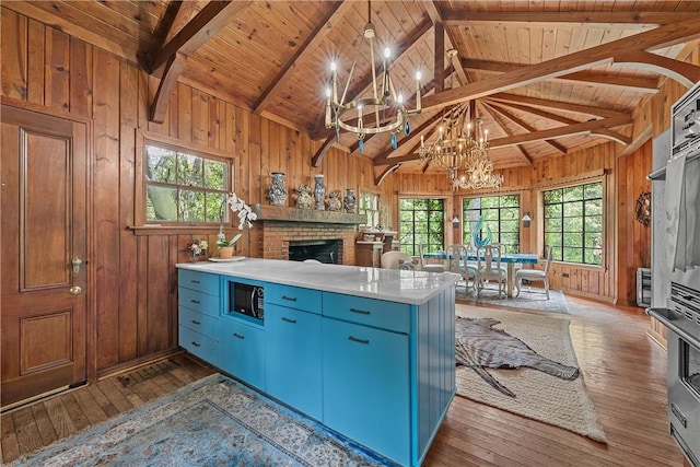 kitchen with dark wood-type flooring, a healthy amount of sunlight, and a brick fireplace