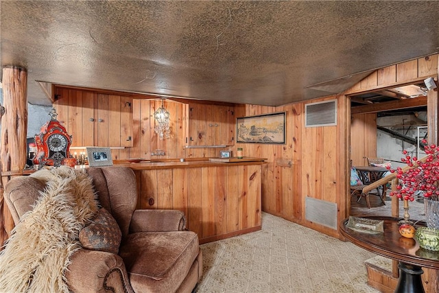 bar featuring wood walls and a textured ceiling