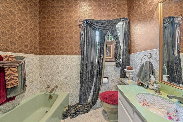 bathroom featuring vanity, toilet, tile walls, and a bathing tub