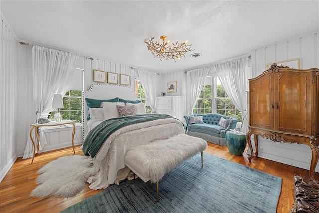 bedroom featuring a notable chandelier and light wood-type flooring