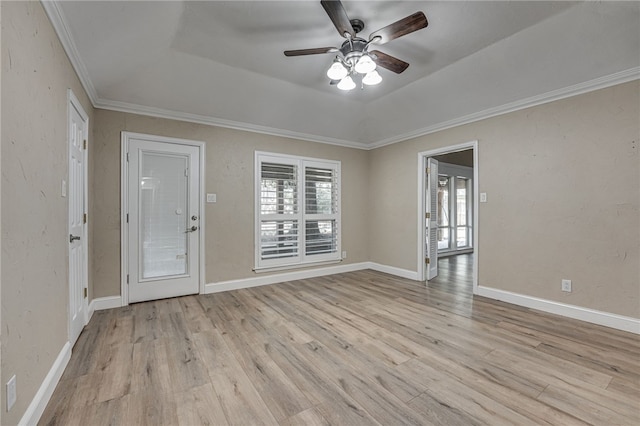 empty room featuring ceiling fan, a raised ceiling, ornamental molding, and light hardwood / wood-style flooring