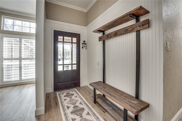 entryway with light wood-type flooring and crown molding